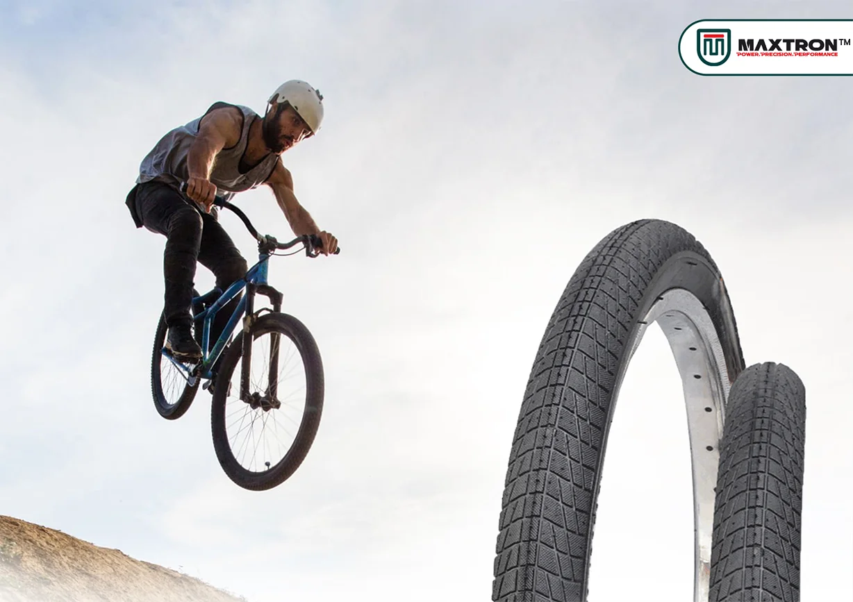 BMX rider performing a dirt jump stunt with Maxtron BMX Dirt tyres displayed, showcasing durable high-performance bicycle tires designed for freestyle riding, dirt tracks, and BMX adventures.
