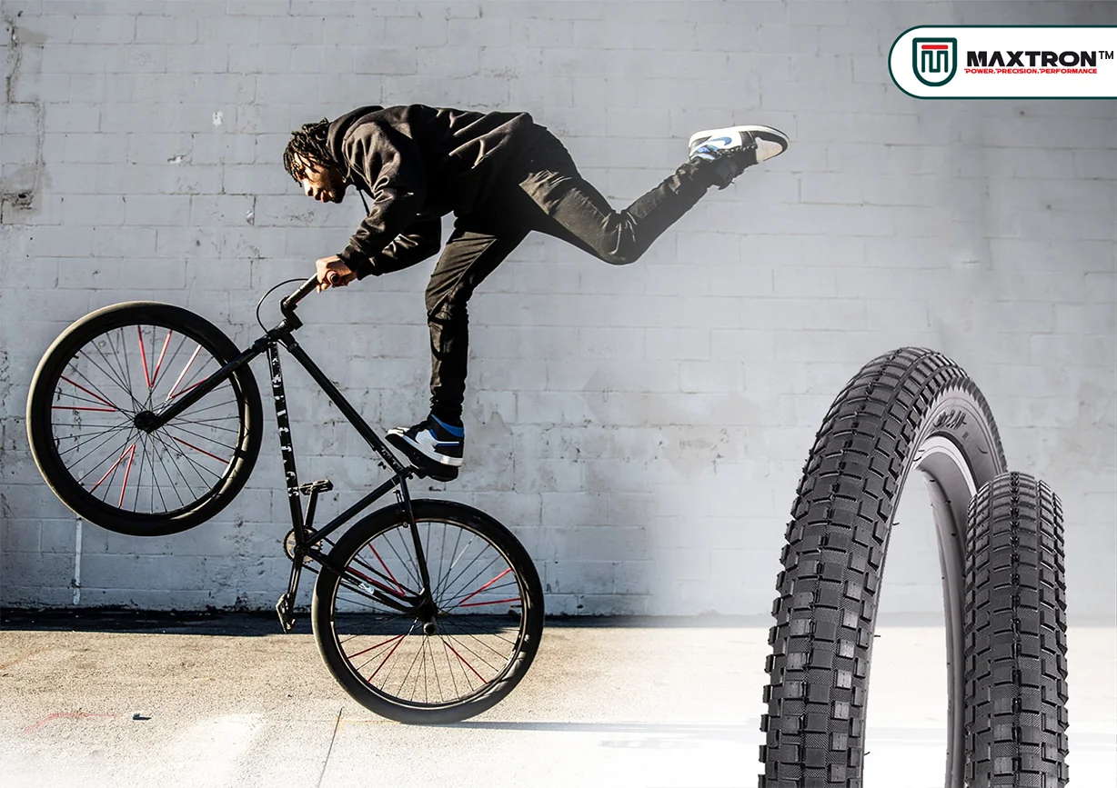 BMX rider performing a freestyle street trick with Maxtron BMX Street tyres displayed, highlighting durable high-grip bicycle tires designed for urban riding, stunts, and freestyle cycling.