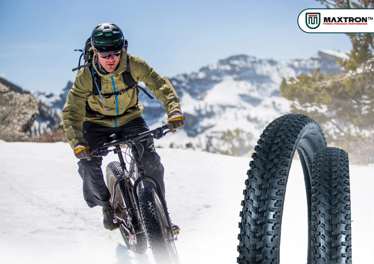 Maxtron MTB bicycle tyres displayed with a mountain biker riding through snowy terrain, showcasing high-grip off-road tires for mountain biking and winter trail adventures.