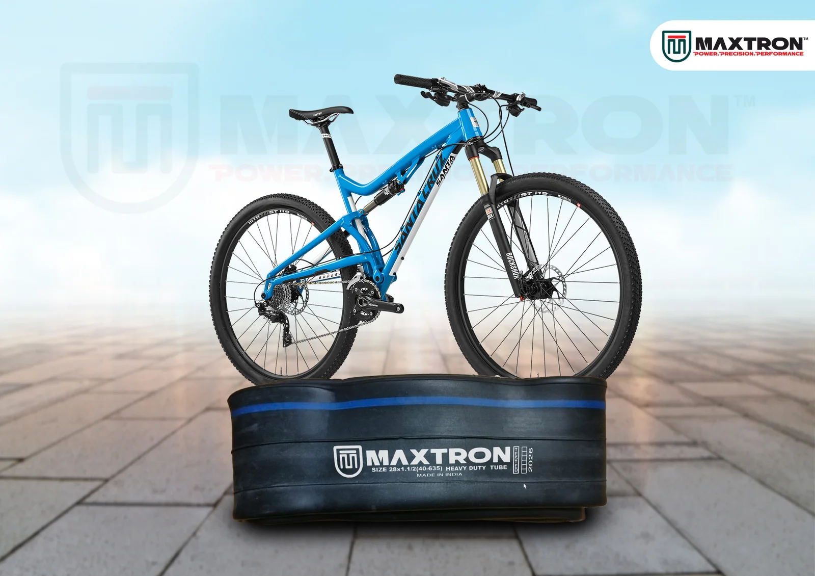 Blue mountain bike displayed above a Maxtron heavy-duty butyl inner tube designed for MTB applications, showcasing durability and performance.