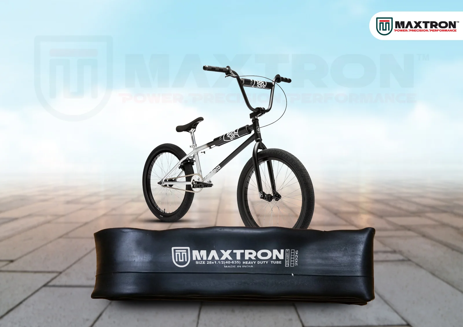 Black and silver BMX bicycle displayed above a Maxtron moulded inner tube, highlighting durability, air retention, and performance for BMX cycling applications.