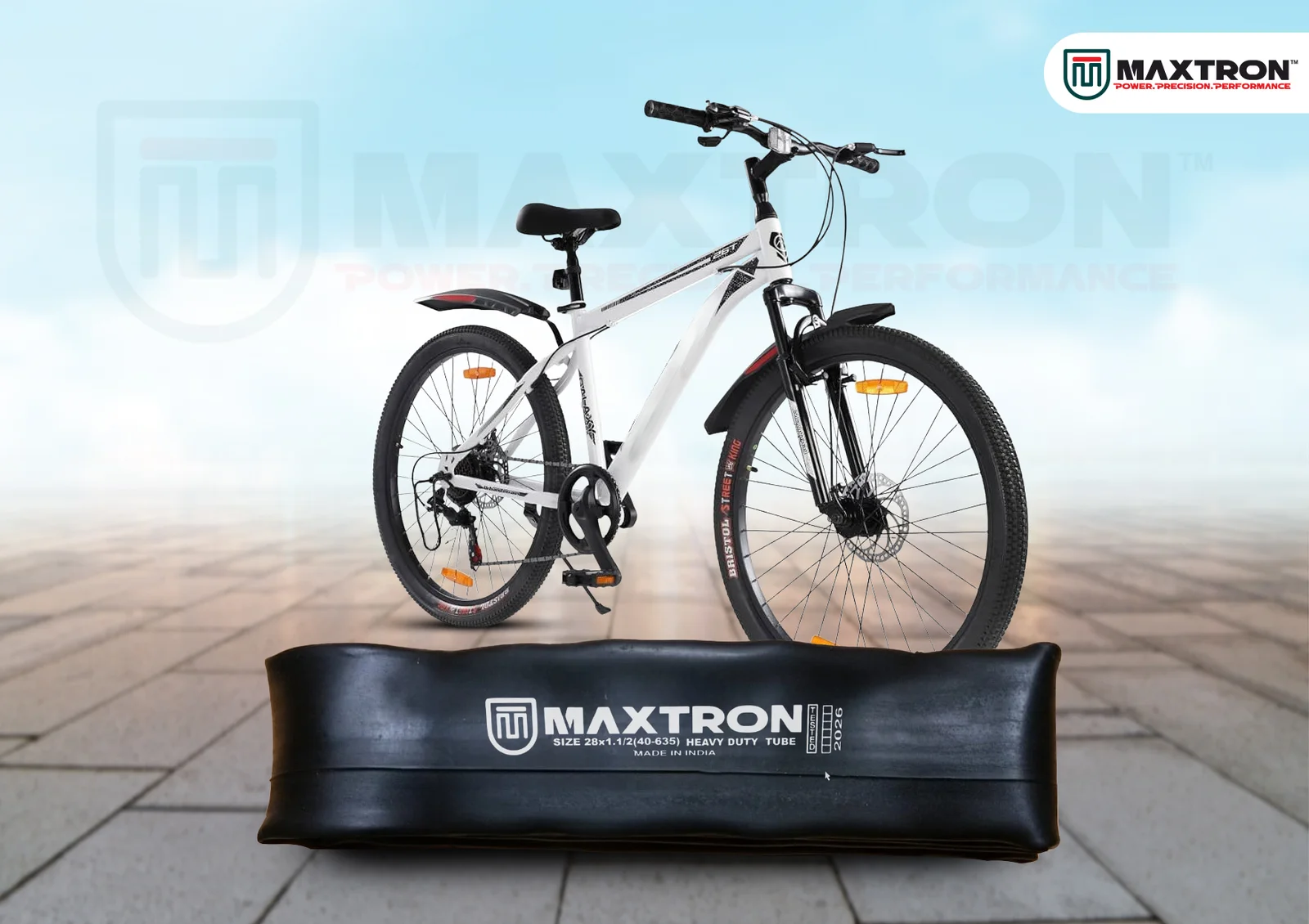 White mountain bike displayed above a Maxtron moulded inner tube, showcasing a durable bicycle tube designed for MTB and hybrid cycling applications.