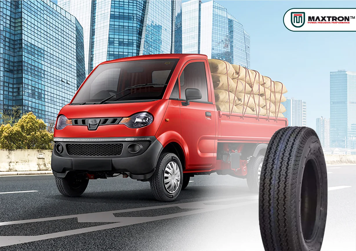 Red cargo three-wheeler pickup vehicle carrying goods with a heavy-duty commercial tyre designed for load carrying, durability, traction, and reliable transportation performance.