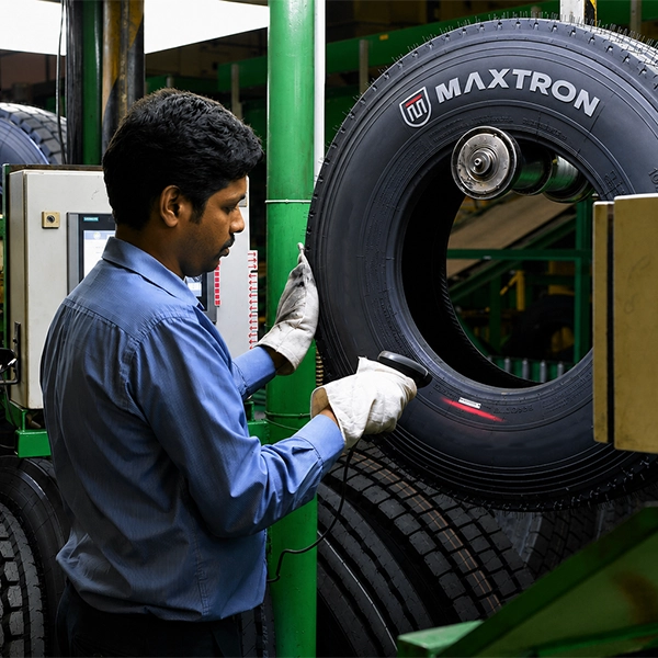 Quality inspection of a Maxtron tyre in a modern manufacturing facility, demonstrating precision engineering, strict quality control and export-ready production standards.