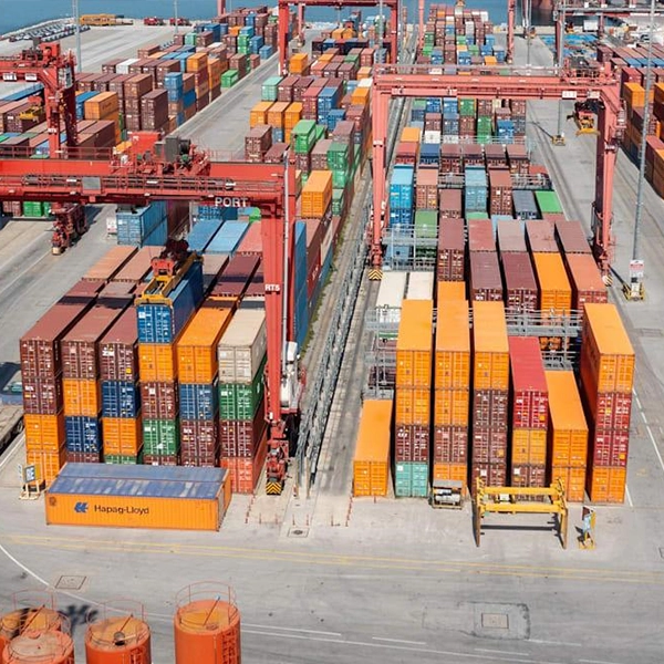 Global shipping port with container handling operations, representing Maxtron's reliable international supply chain, export logistics and worldwide distribution network for tyres and tubes.