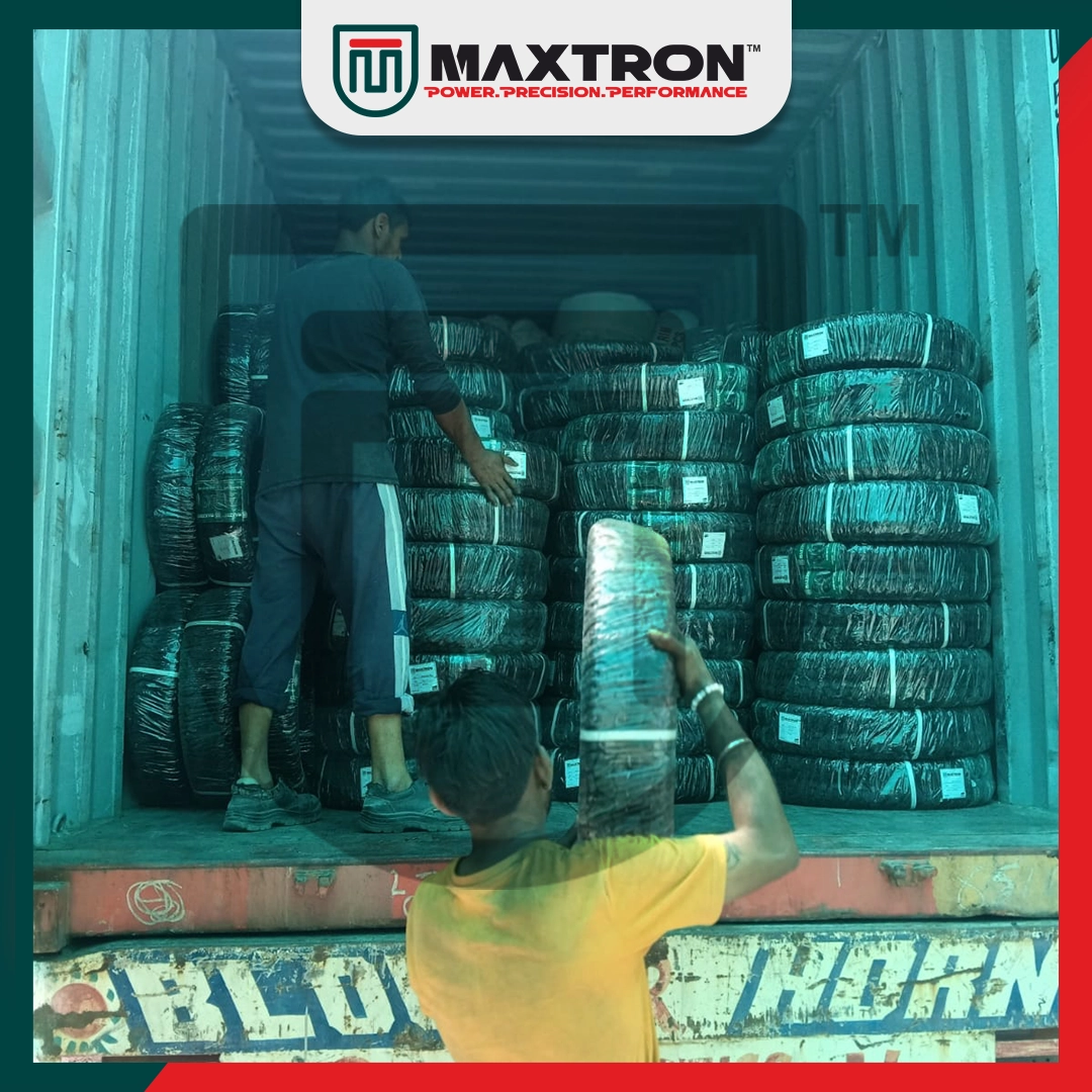 Workers loading Maxtron bicycle tyres into an export shipping container with securely packed tyres prepared for international B2B distribution.