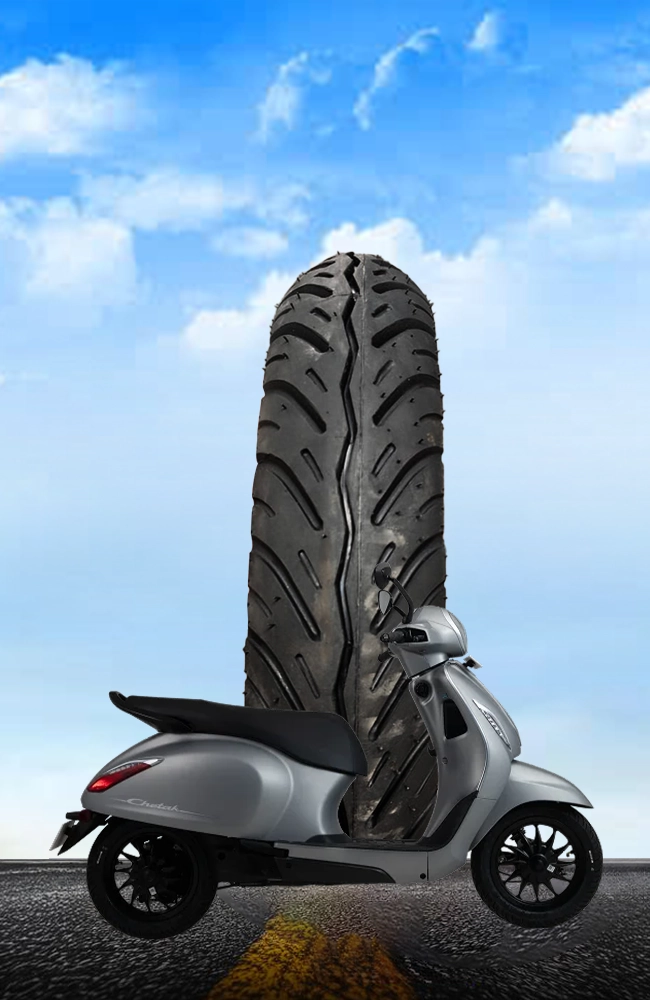 Premium Maxtron scooter tyre with modern tread pattern displayed alongside a grey scooter on a road, representing durable urban commuting tyres.